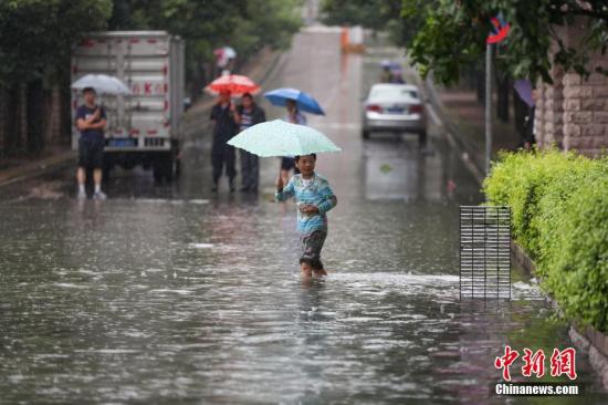 市民在积水的门路中出行。中新社记者 贺俊怡 摄