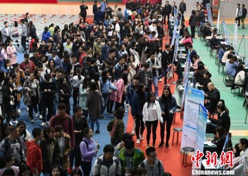 资料图:众多大学生扎堆招聘现场求职。 杨华峰 摄