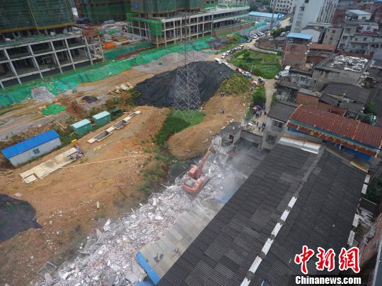 图为城管部门拆除该违建楼房。 朱开健 摄