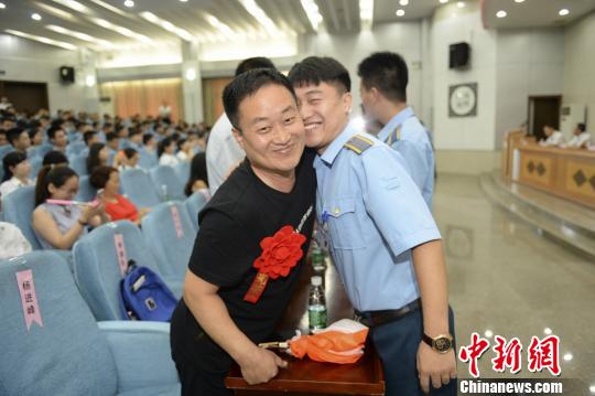 毕业生与父亲在毕业典礼上相拥。 杨华峰 摄