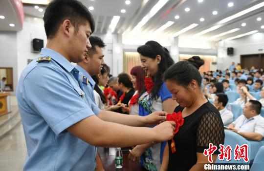 毕业生为母亲戴上代表光荣的红花。 杨华峰 摄