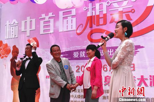 图为相亲现场牵手成功的第一对有情人,获得赞助商提供的一枚钻戒。 赵江梅 摄