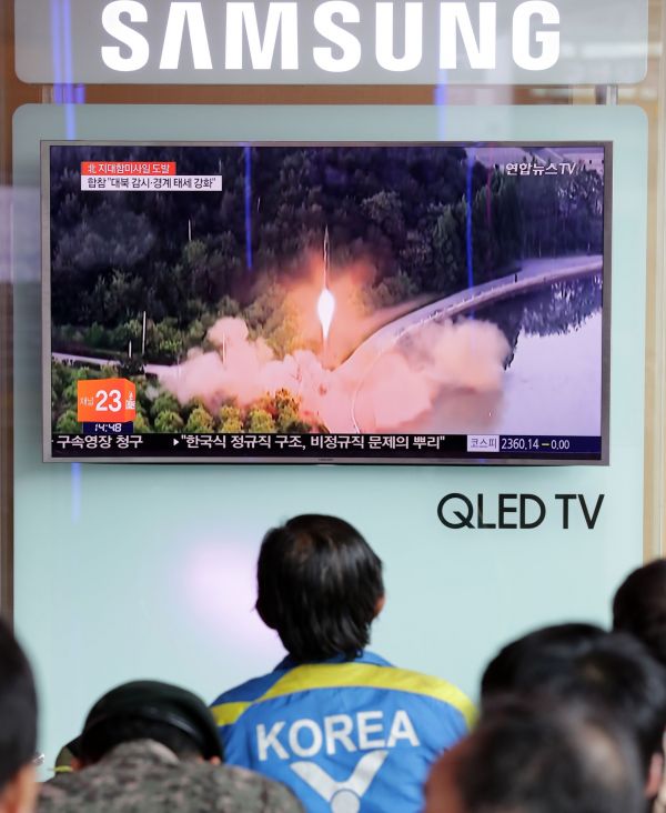 6月8日,在韩国首尔火车站,韩国民众寓目相关新闻。韩国军方8日称,朝鲜当天早晨向朝鲜半岛东部海域偏向试射多枚航行物,推测为地对舰导弹。新华社发(李相浩摄)