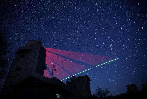 2016年11月9日,在河北兴隆观测站,“墨子号”量子科学实验卫星过境,科研人员在做实验(合成照片)。新华社记者 金立旺 摄