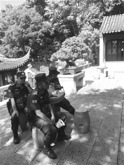  景区保安拿着喇叭对着“合唱团”播放“文明公约”。