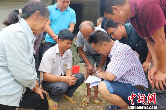 村民在领鱼苗前登记签名。 林馨 摄