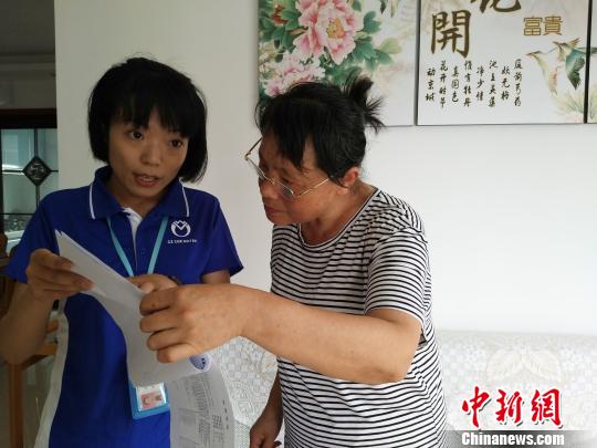 工作人员向居民解释检测报告指标图 魏佳文 摄