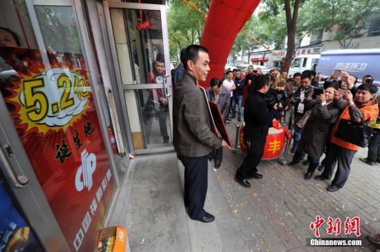 10月11日,在山西太原5.2亿元人民币福彩大奖诞生投注站,站主杨文生收到当地福彩中心发放的奖励后,引来周围民众的围观。10月5日晚,中国福利彩票双色球游戏第14115期开奖,当期双色球头奖开107注,单注奖金为520.68万元,其中山西独揽101注,奖金高达5.2亿,是中国彩票史上第三大奖。一时间,“买彩票中大奖”成为当地民众坊间热议的话题,5.2亿福彩大奖诞生投注站也成彩民争相前往的“景点”。<a target=\'_blank\' href=\'http://www.chinanews.com/\'>中新社</a>发 韦亮 摄