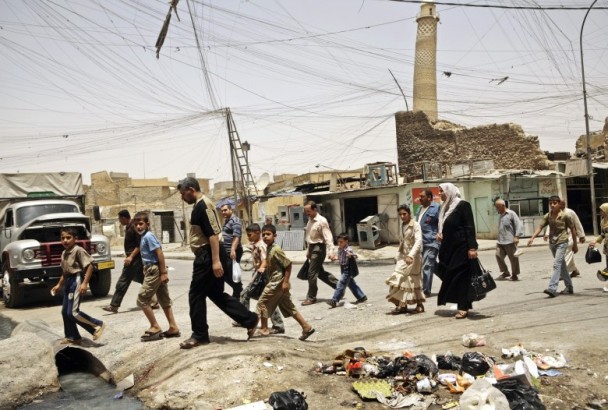  伊拉克民众在努里清真寺以其倾斜尖塔旁走过。（图片来源：美联社）