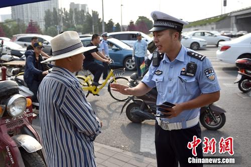 6月21日上午,北京交警敖翔处理交通违法行为。中新网记者 金硕 摄