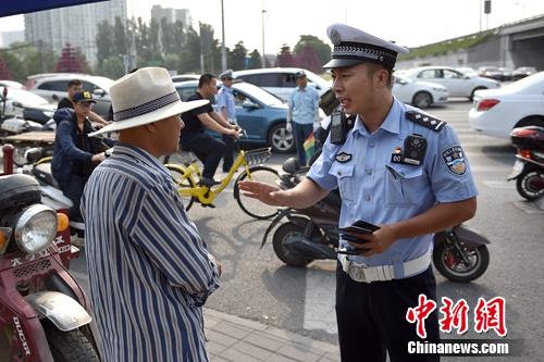 6月21日上午，北京交警敖翔处理交通违法行为。中新网记者 金硕 摄