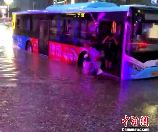 近日，兰州公交司机刘惠俊走红网络。一组网友拍摄刘惠俊在大雨中多趟涉水背乘客过积水的图片在社交网络中“刷屏”。图为公交司机涉水背乘客过积水。　视频截图　摄