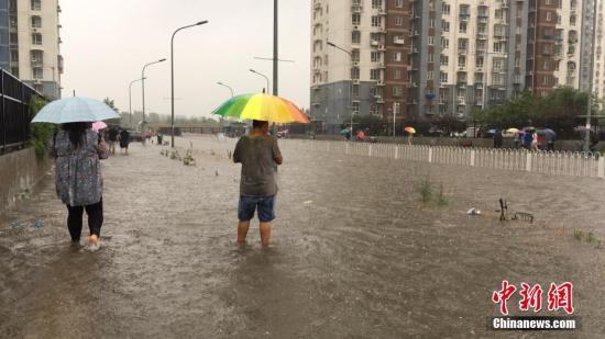 资料图：北京现大雨，民众冒雨前行。中新网记者 赵姗姗 摄