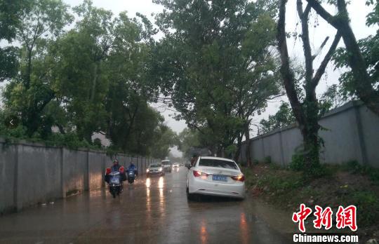 6月23日傍晚，江西省南昌市暴雨如注造成局部道路积水，一辆白色轿车误判路况，陷入水沟无法动弹。　吴艳珍　摄