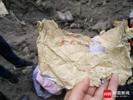 昨(24)日,救援职员在现场挖出来的张娇的作业本