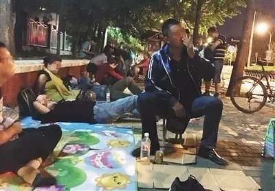 ▲6月8日晚11时许，北京大学口腔医院门外的人行道上已排起长队，其中有20多人为兼职号贩子。