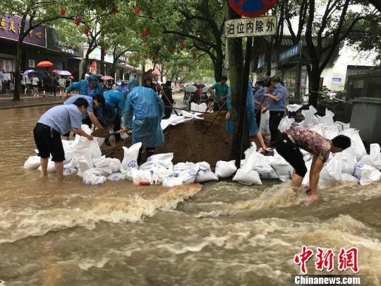 [图为兰溪民众协力堆沙包，严防死守汛情 奚金燕 摄] 图为兰溪民众协力堆沙包，严防死守汛情 奚金燕 摄