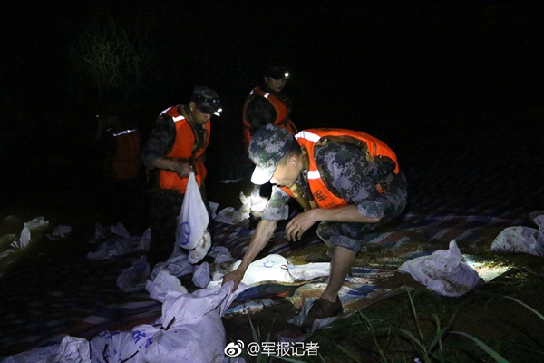 昨夜,解放军官兵坚守在兰溪洪峰一线,加固堤坝1000余米。(图片来源:新浪微博@军报记者)