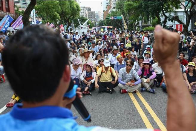  图为“立法院”26日继续审查年金改革相关“法案”，反年改团体也在“立法院”周边发动陈抗，有民众选择静坐表达诉求。（图片来源：台湾“中时电子报”）