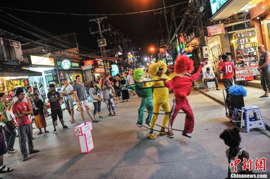 资料图:普吉岛被誉为泰国的“珍珠”,这里拥有迷人的风光和丰富的旅游资源,每年都吸引众多游客来此休闲观光。图为一名街头艺术家在进行表演。洪坚鹏 摄 今年前5月泰国旅游业收益增长 海岛观光仍大热