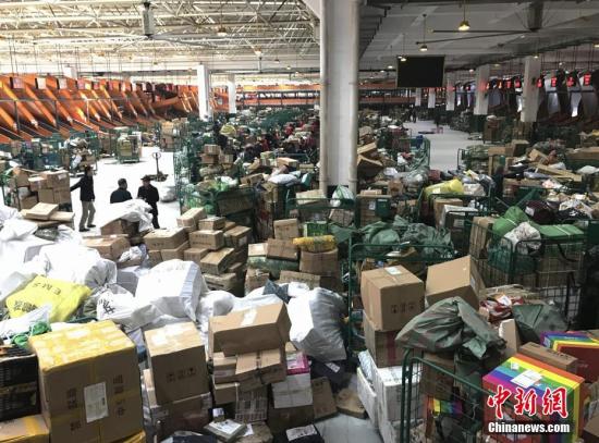 1月20日,湖南长沙邮区中心局的工作人员正在处理堆积的快递包裹。随着中国春节的临近,为了避开实体店购物的拥挤和繁琐,越来越多的人选择网络购置年货,快递行业也随之迎来“春运”高峰。中新社记者 唐小晴 摄
