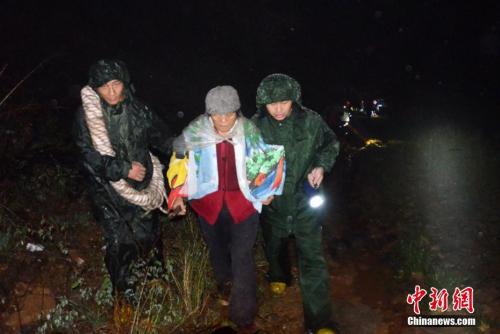 资料图:消防官兵冒雨紧急护送民众转移至安全地带。 吴从昊 摄