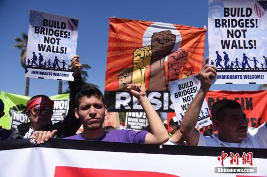 资料图:美国洛杉矶,民众手举标语、高呼口号,表达自己的诉求。<a target=\'_blank\' href=\'http://www.chinanews.com/\'>中新社</a>记者 张朔 摄