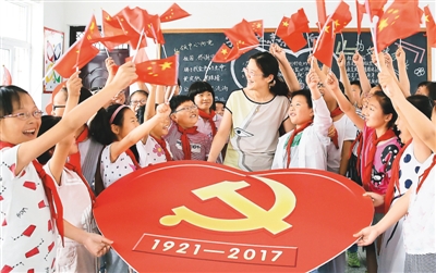 图为江苏省海安县南莫镇中心小学的老师为学生们讲解党徽知识。向中林摄