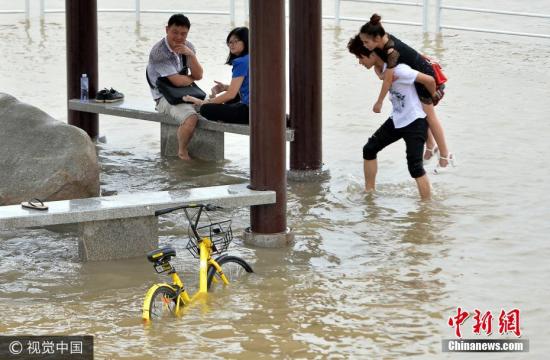 2017年6月29日，在武汉市武昌黄花矶，图为市民在江水漫过的亲水平台上。图片来源：视觉中国