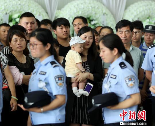 牺牲民警钱宗清的妻子和6个月大的女儿来送钱宗清最后一程。　沈果　摄