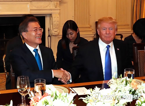 当地时间6月29日，在美国白宫，韩国总统文在寅（左）与美国总统特朗普在晚宴开始前握手合影。（韩联社）