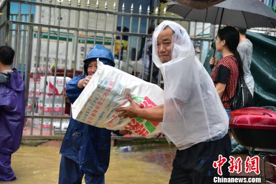 7月2日，柳州市沿江一带的居民忙着搬运物资。　王以照 摄