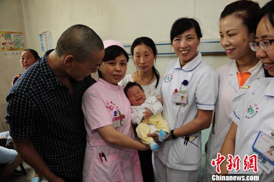 出院前，医务职员与乔大帅一家三口在一起。　王一生　摄