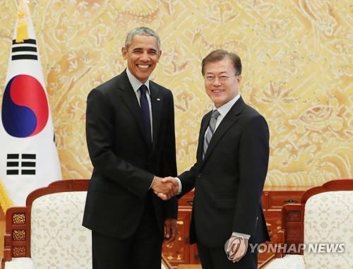7月3日下午，韩国总统府青瓦台，文在寅与到访的奥巴马握手。(图片来源：韩联社)