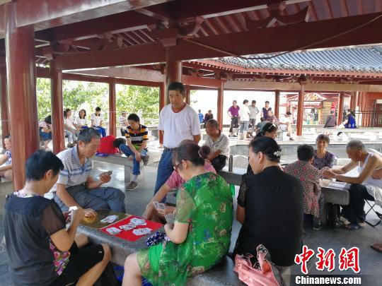 江边凉亭群集了大批休闲娱乐的市民。　卢文伟　摄