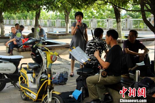 沿江风景带上，市民在唱歌娱乐。　卢文伟　摄