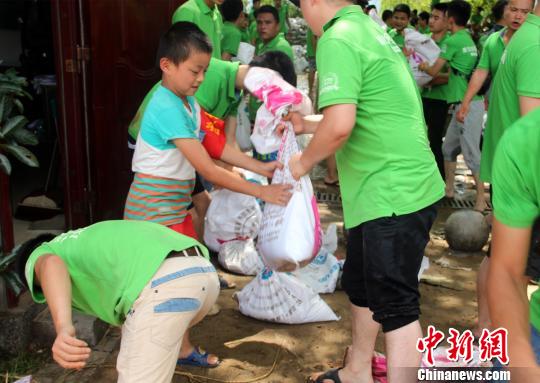 圖為一名小志願者加入正在轉移沙袋的志願者隊伍。　盧文偉 攝