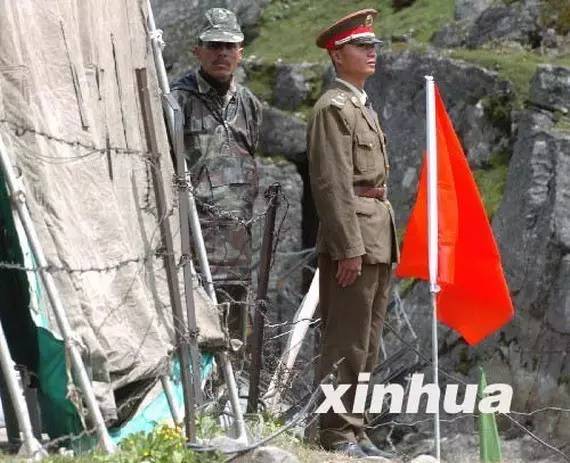 资料图： 2006年7月5日，在中印疆域乃堆拉山口，一名中国边防武士（右）与一名印度边防武士隔着界限的铁丝网值勤。新华社记者 韩传号 摄