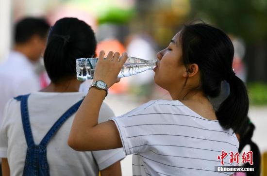 7月6日,新疆乌鲁木齐市最高温度达到36摄氏度,一位市民躲在阴凉处大口喝水。 <a target=\'_blank\' href=\'http://www.chinanews.com/\'>中新社</a>记者 刘新 摄
