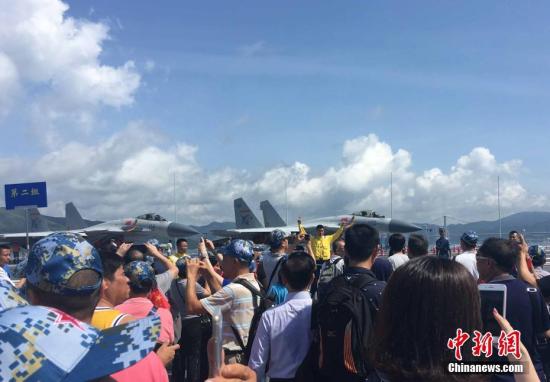 7月9日，香港晴空万里，阳光普照，中国首艘航母辽宁舰第二天开放予香港市民参观。大批市民登上辽宁舰欣喜拍照。中新社记者 阎宇赫 摄