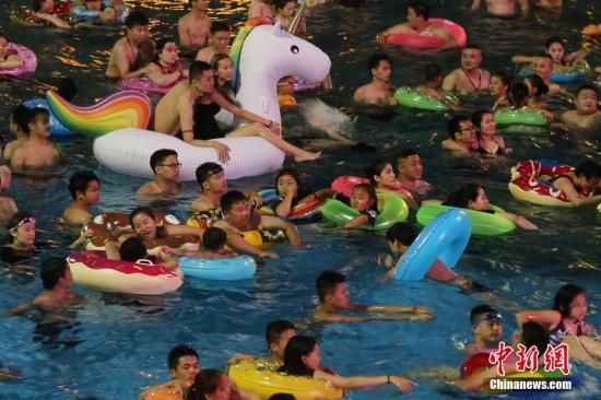 资料图：7月8日晚，民众在冲浪池中戏水。 中新社记者 泱波 摄