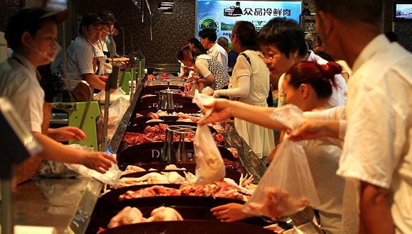 2016年6月，河南许昌市民在一家生活超市购买猪肉。 图片来源：视觉中国