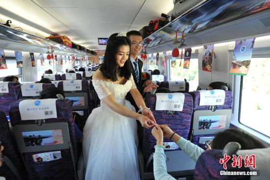 百对新人宝兰高铁上举行集体婚礼开启蜜月之旅。图为新人向旅客送上喜糖。杨艳敏 摄 资料图:百对新人宝兰高铁上举行集体婚礼开启蜜月之旅。图为新人向旅客送上喜糖。杨艳敏 摄