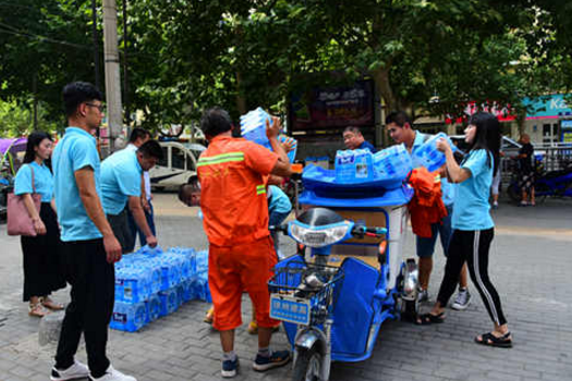 暖心!河南大学生卖报纸挣钱 为环卫工送清凉