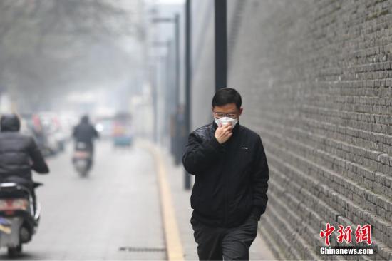 资料图:雾霾天气市民戴口罩出行。张远 摄