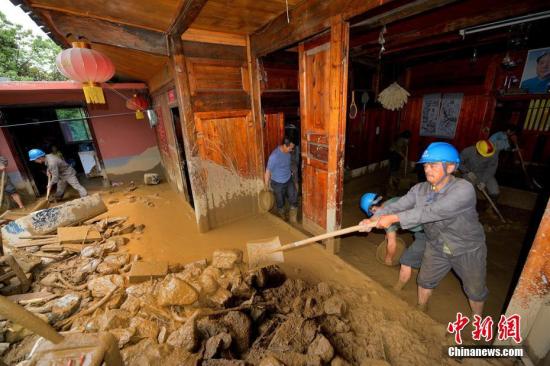 湖北省五峰土家族自治县7月14日至15日遭遇特大暴雨袭击,导致山洪暴发、河水猛涨,基础设施、水利设施损失严重。图为摄救援队帮助受灾户清除家中淤泥。雷勇 摄