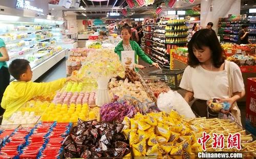 7月17日，中国国家统计局发布的数据显示，1至6月中国社会消费品零售总额同比名义增长10.4%。图为成都某超市内正在选购糖果的民众。 中新社记者 刘忠俊 摄