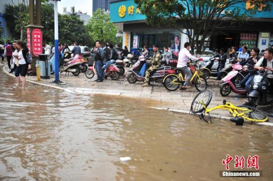 众多上班族被积水困在路上无法前行。 <a target='_blank' href='http://www.chinanews.com/'>中新社</a>记者 刘冉阳 摄 昆明暴雨城市内涝,众多上班族被积水困在路上无法前行。 中新社记者 刘冉阳 摄