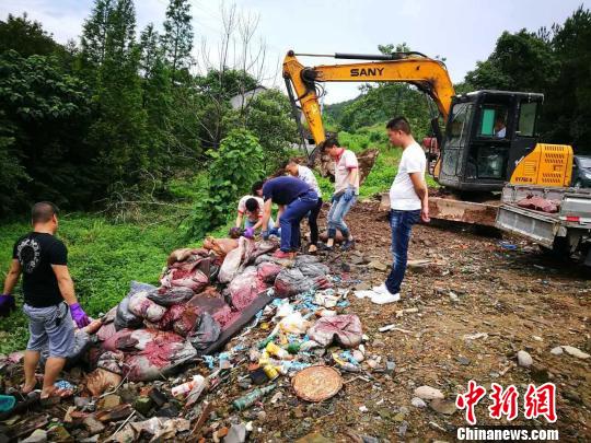 在告发职员的指引下,执法观察职员发现路边斜坡处数十只沁着斑驳的白色、蓝色的编织袋聚集如山。金华市环保局提供