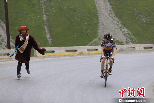 图为一名祁连藏族民众为车手加油 胡贵龙 摄